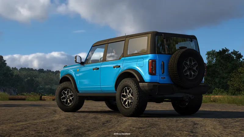 Light blue four-door Ford Bronco on a gravel lot in American Truck Simulator Road Trip