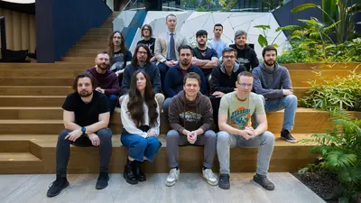 Group photo of the SCS Software Road Trip team sitting on wooden steps at the studio