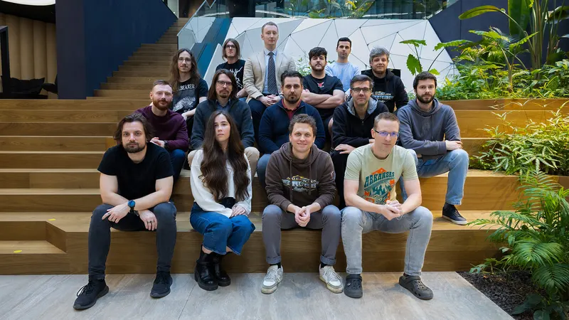 Group photo of the SCS Software Road Trip team sitting on wooden steps at the studio