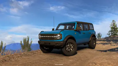 Blue 2023 Ford Bronco Badlands on a dirt hilltop trail in American Truck Simulator Road Trip