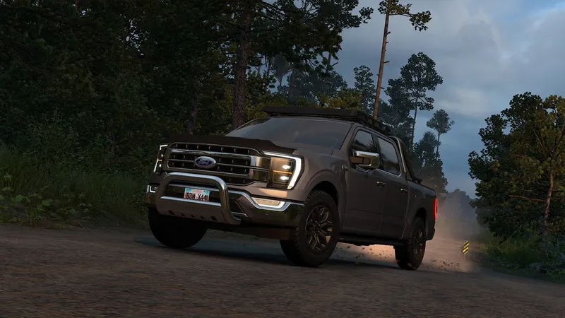 Dark Ford F-150 with a bull bar on a forest road at dusk in ATS Road Trip