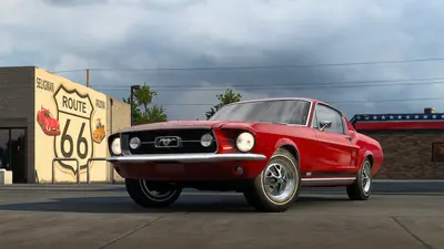 Red 1967 Ford Mustang Fastback parked by a Route 66 mural in ATS Road Trip